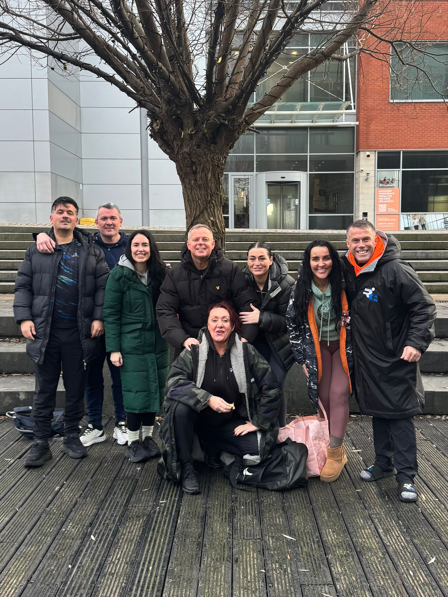 Recovery Group About Us page - a group of people stood next to a tree, outside a building